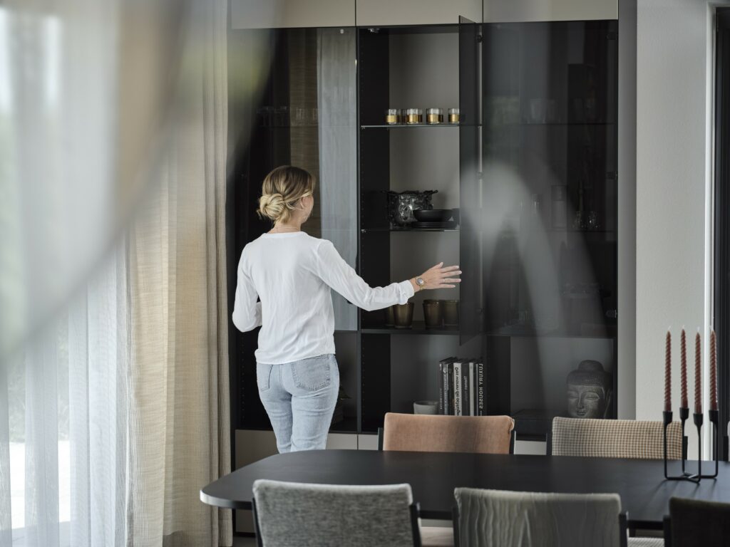 Glasvitrine mit dunklem Glas. Zufriedene Kunden öffnet die Vitrine.