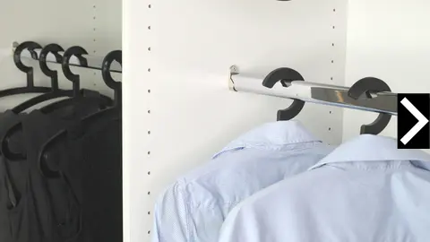 Kleiderschrank mit Kleiderstange an der Hemden auf Kleiderbügeln hängen